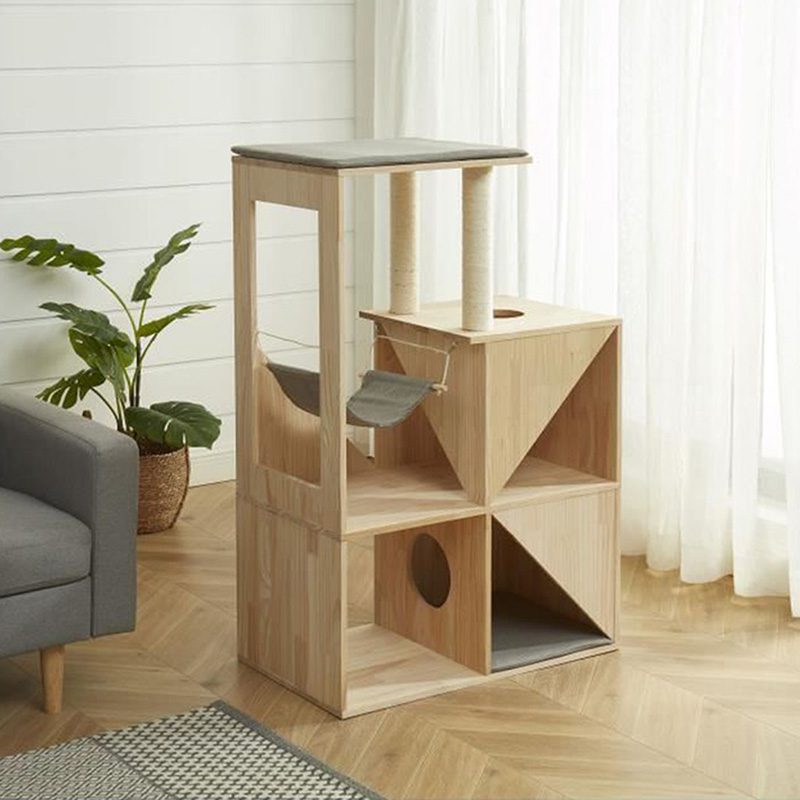 Arbre à chat design en bois avec coussin, hamac et poteaux en sisal vu de trois quart dans un salon.